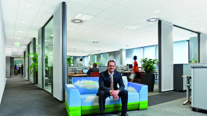 Ein Mann sitzt auf einer Couch in einem Korridor mit Beleuchtung von Philips an einem Standort von Audi