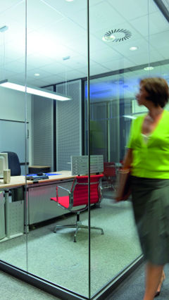 Une femme observe les bureaux privés d'Audi, mis en lumière par une solution d'éclairage de Philips