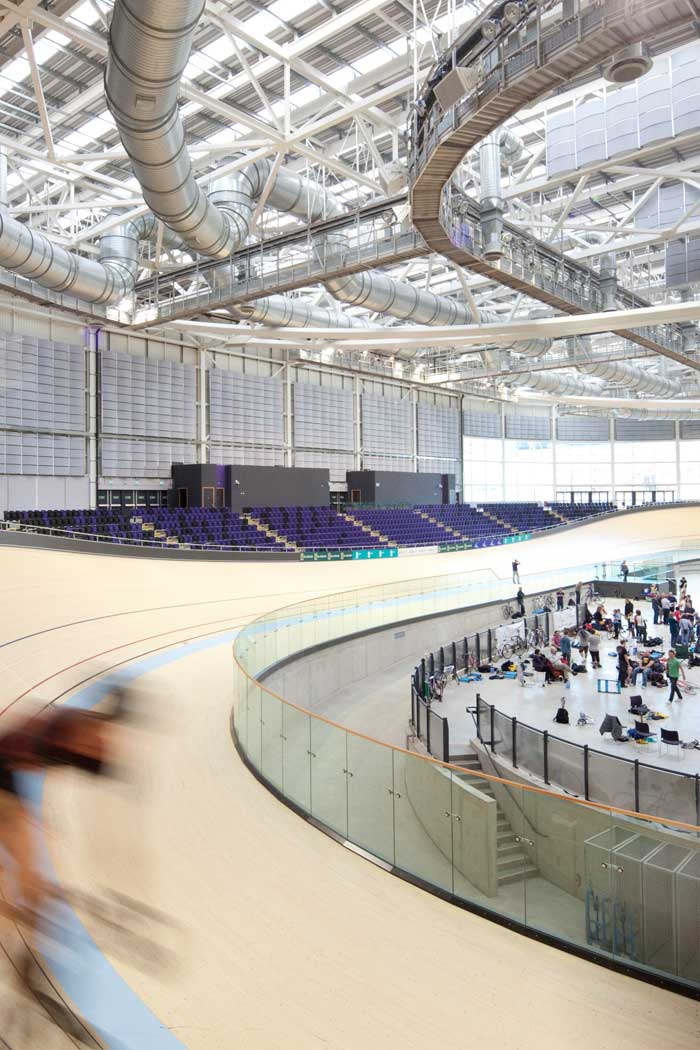 Des cyclistes dans l'Emirates Arena, au Royaume-Uni, mis en lumière par les solutions d'éclairage sportif Philips