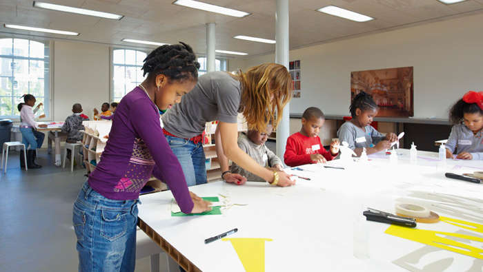 Des étudiants participent à des ateliers dans une classe au Hermitage Amsterdam mise en lumière par l'éclairage faible consommation Philips 
