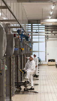 Des employés au travail dans l’usine Hero, en Espagne, mise en lumière par un éclairage LED Philips à économie d’énergie