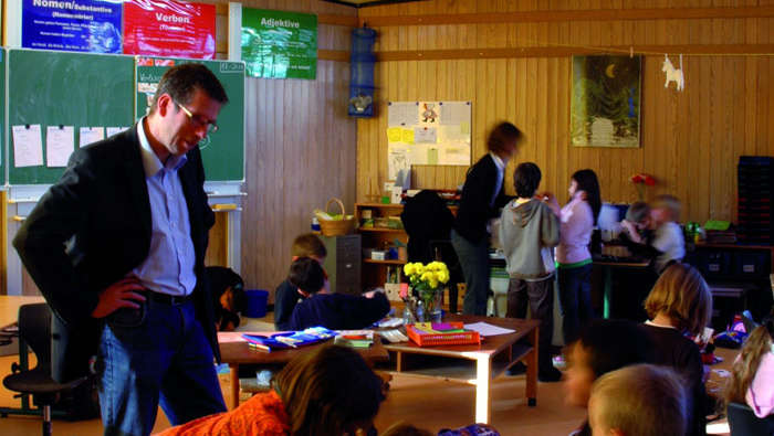 Un professeur aide les étudiants à In der Alten Forst, sous l'éclairage pour écoles de Philips