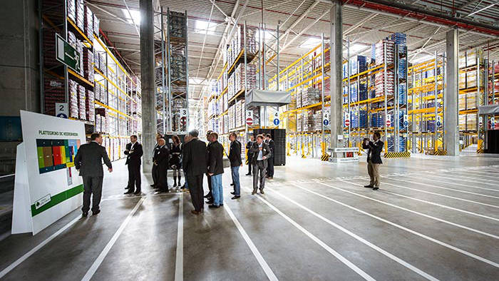 Des individus assistent à une présentation au sein de l'entrepôt du centre de distribution de Lidl, mis en lumière par Philips Lighting