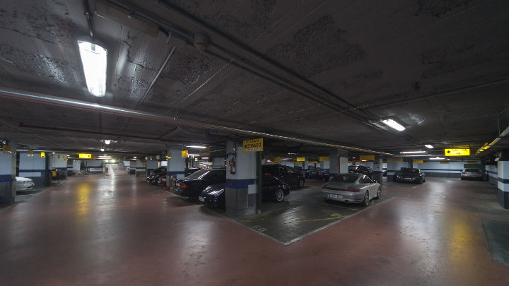 Des voitures garées dans le parking de l’hôtel NH, sous un éclairage Philips