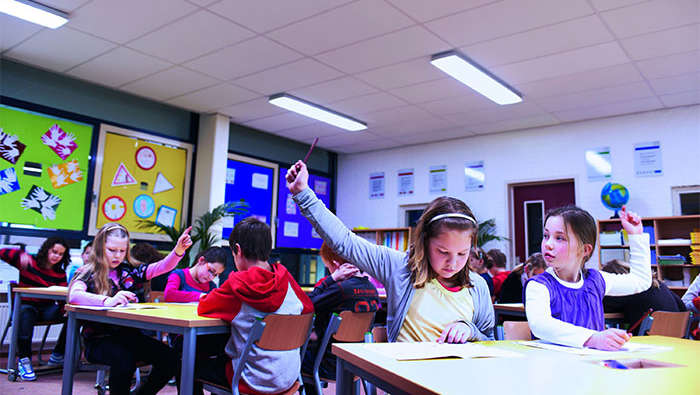 Schulkinder an der Grundschule Wintelre, wo durch Philips Beleuchtung eine helle Lernatmosphäre im Klassenraum geschaffen wurde