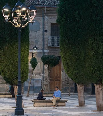 Un homme et un enfant jouent aux cartes dans une rue de Palencia, mise en lumière par une solution d'éclairage de Philips