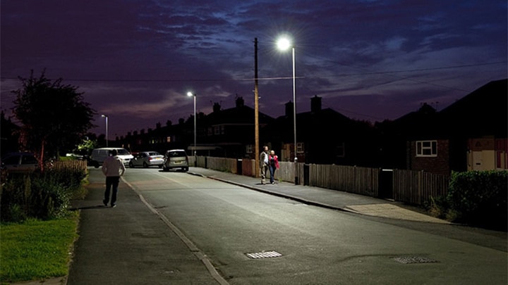 Piétons marchant dans une rue mise en lumière par Philips