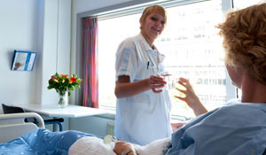 Nurse is offering a glass of water to a patient