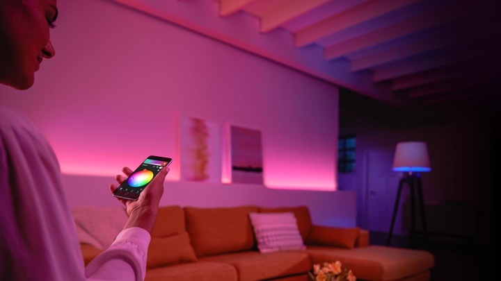 Mann der die Lichtfarbe über die Philips Hue-App anpasst