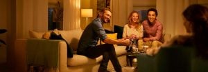 "L'éclairage LED chaleureux crée une ambiance chaleureuse pour les amis qui se retrouvent dans le salon, soulignant l'éclairage économe en énergie pour les réunions en soirée."