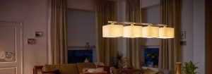 La suspension LED moderne avec plusieurs abat-jours en tissu illumine un salon confortable, présentant des solutions d'éclairage domestique élégantes et économes en énergie pour un confort ambiant en soirée.