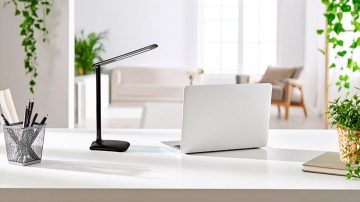 Une lampe de table sur un bureau orienté vers le papier et le stylo