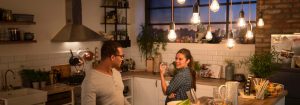 "Cuisine moderne avec des suspensions LED de style vintage illuminant deux femmes en train de dîner, créant une atmosphère chaleureuse et accueillante. »