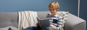 "Un enfant lit sous une douce lumière LED, offrant un éclairage confortable pour les heures de contes du soir et favorisant des habitudes de sommeil saines dans une chambre confortable. »