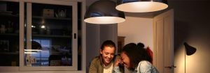 "Les suspensions LED modernes créent une atmosphère chaleureuse pour deux femmes qui apprécient la conversation, mettant en valeur des solutions d'éclairage de Habitat écoénergétiques. »